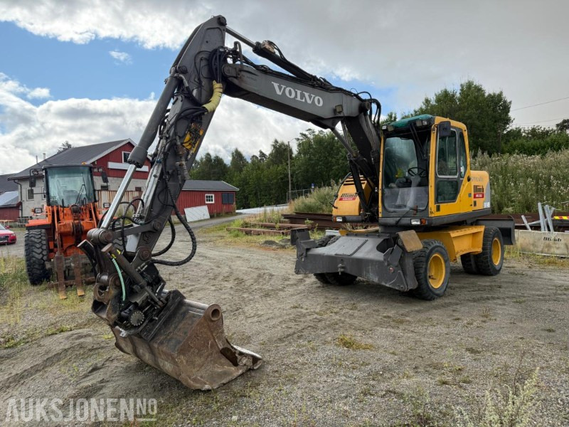 2006 Volvo EW140B Hjulgraver m/pallegaffel og skuff - Steelwrist tiltrotator. - Pelle: photos 1 2006 Volvo EW140B Hjulgraver m/pallegaffel og skuff - Steelwrist tiltrotator. - Pelle: photos 1